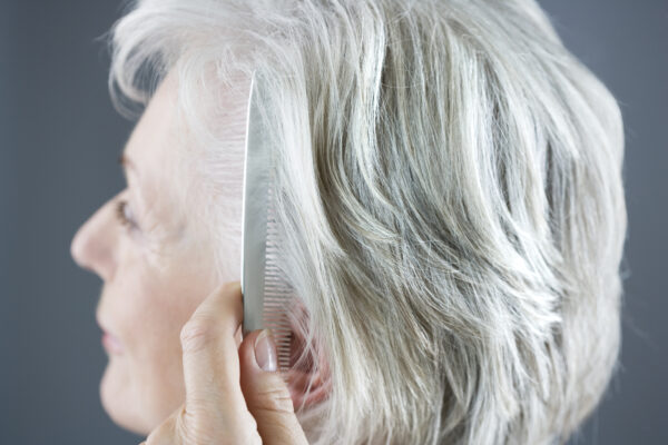 Senior woman combing her hair